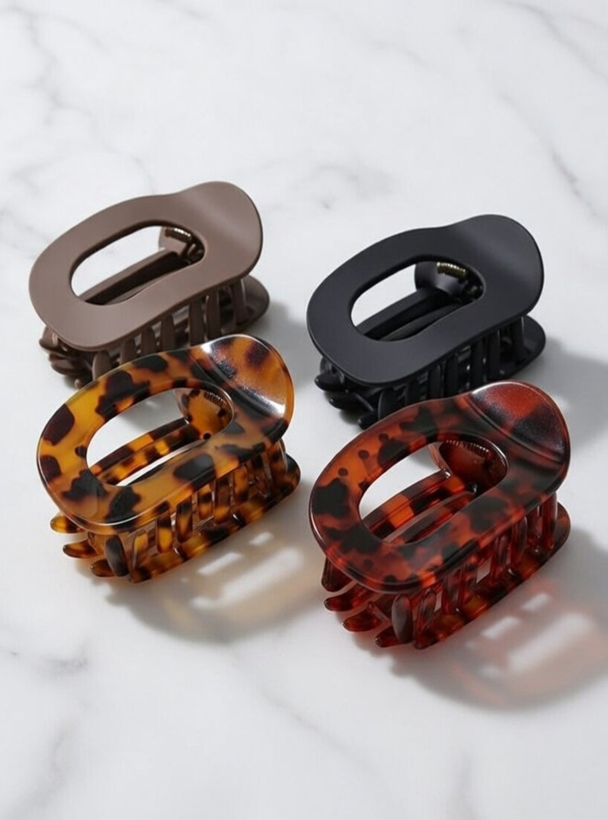 Four hair clips in different colors on a white background