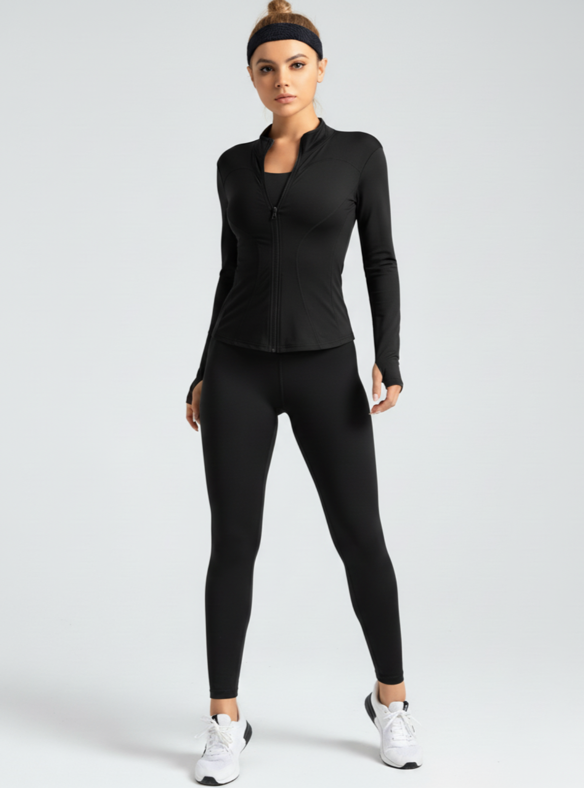 Woman wearing a black athletic outfit on a white background