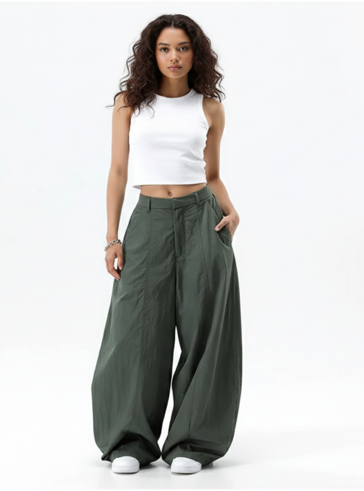 Woman wearing a white top and green wide-leg pants on a white background