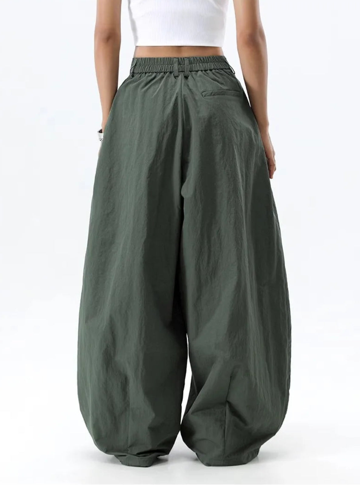 Green wide-leg pants worn by a person on a white background