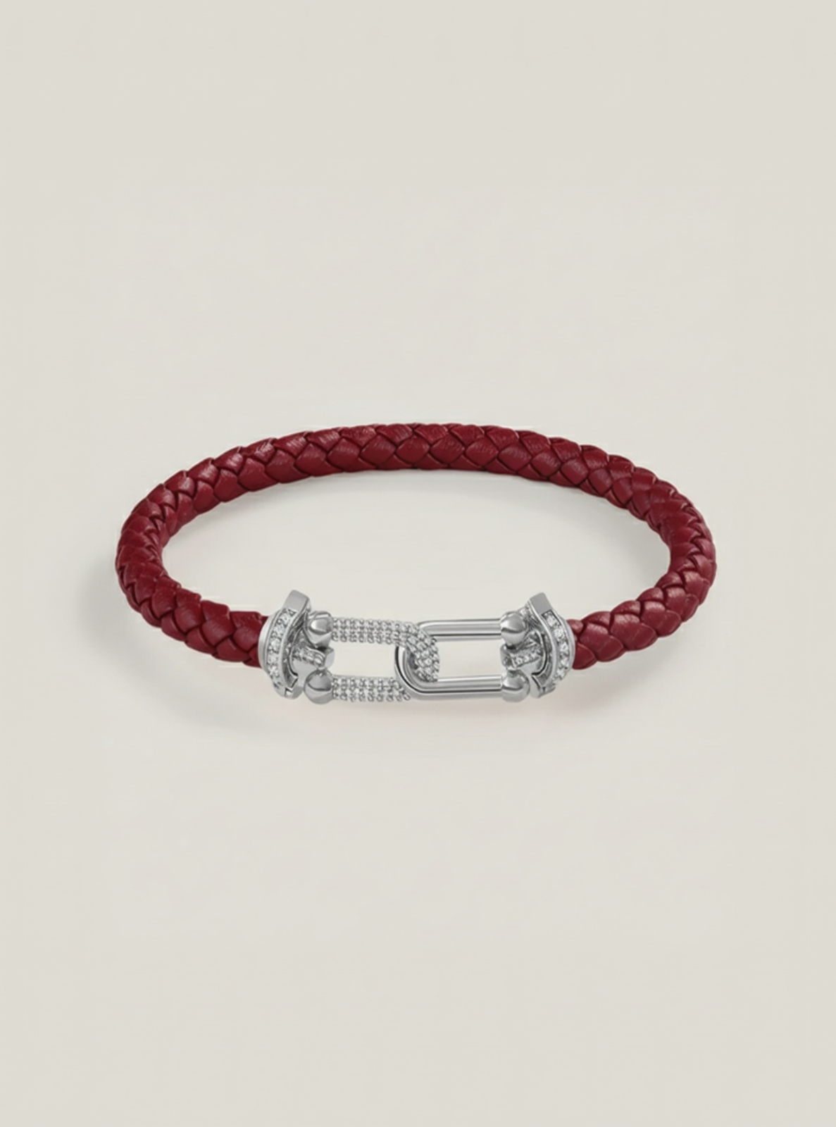 Red braided leather bracelet with a silver clasp on a light gray background