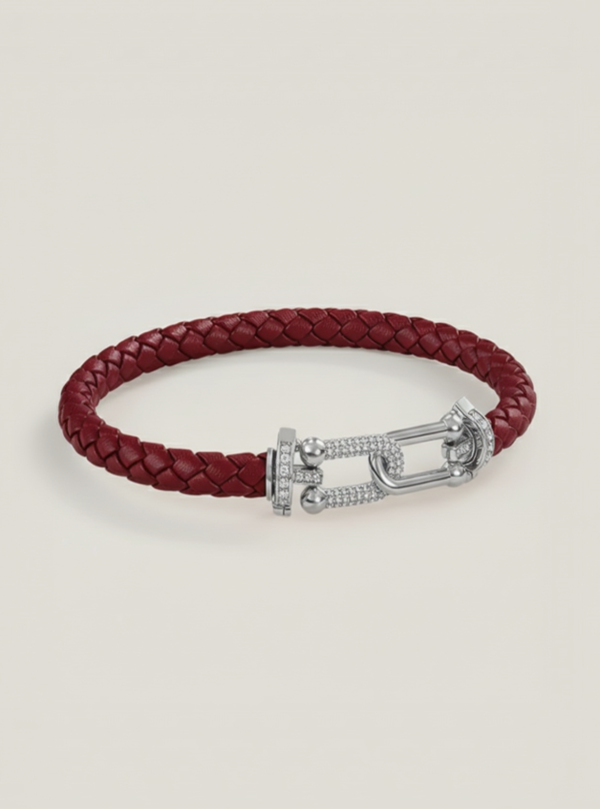 Red braided leather bracelet with a silver clasp on a light gray background