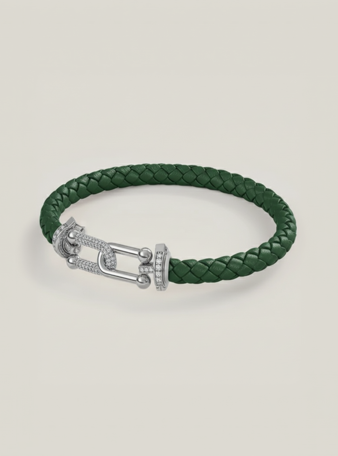 Green braided bracelet with a silver clasp on a light beige background
