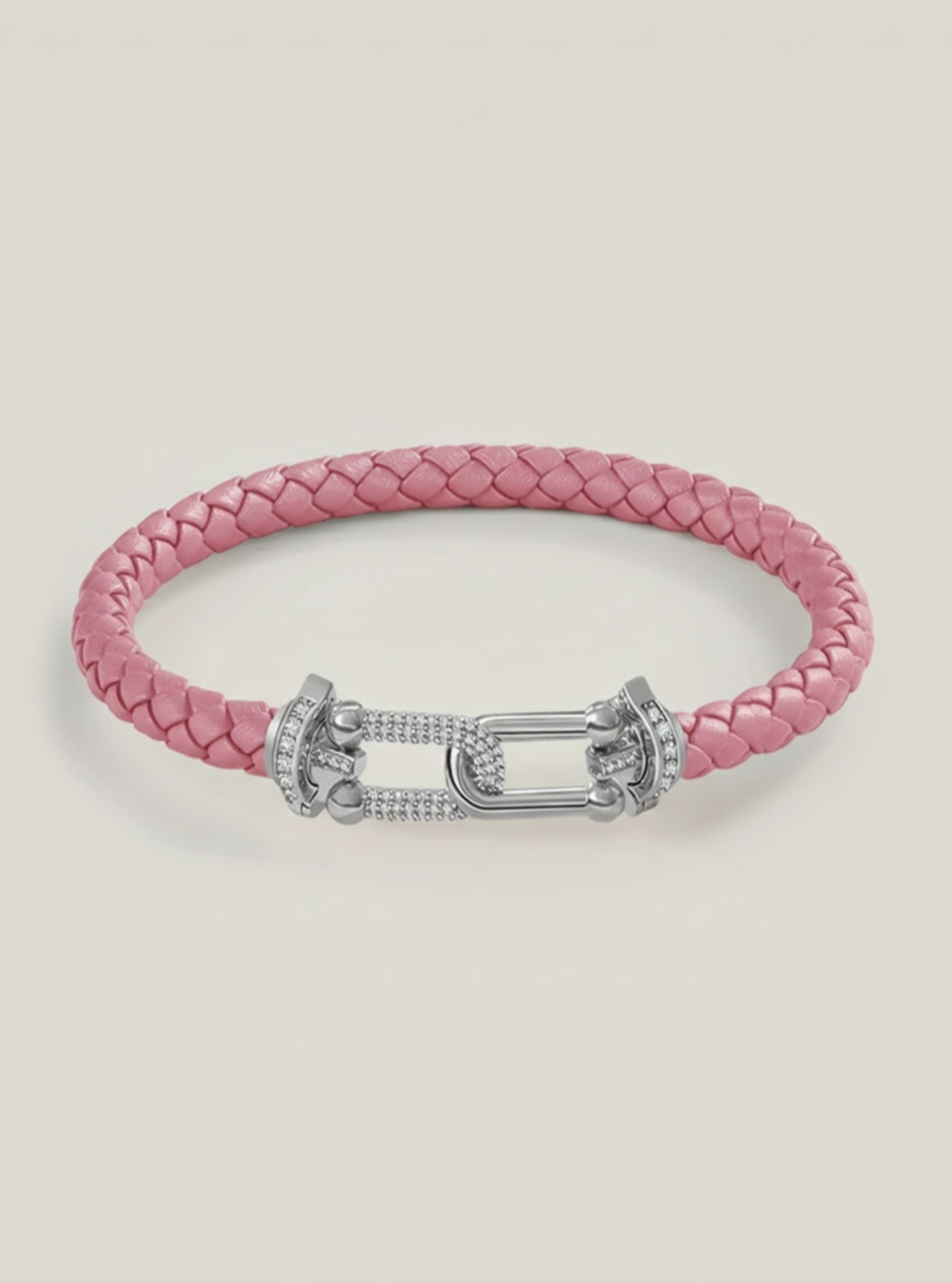 Pink braided bracelet with a silver clasp on a light gray background