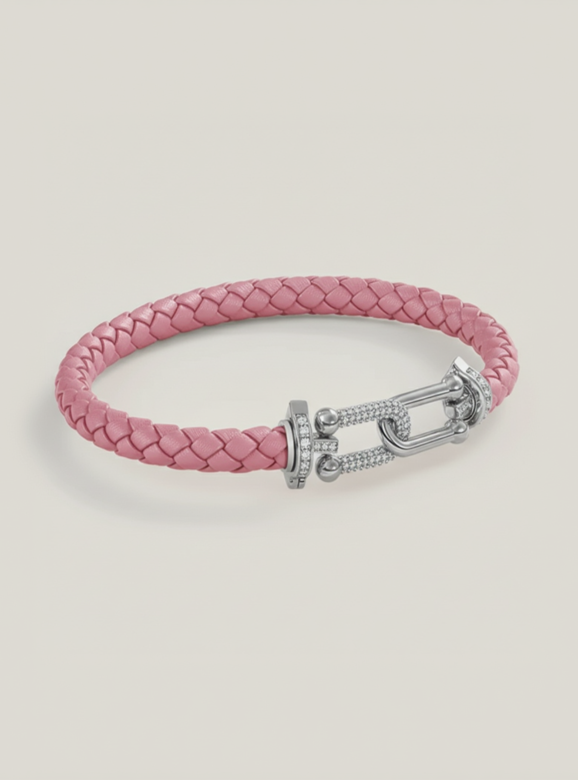 Pink braided bracelet with a silver clasp on a light gray background