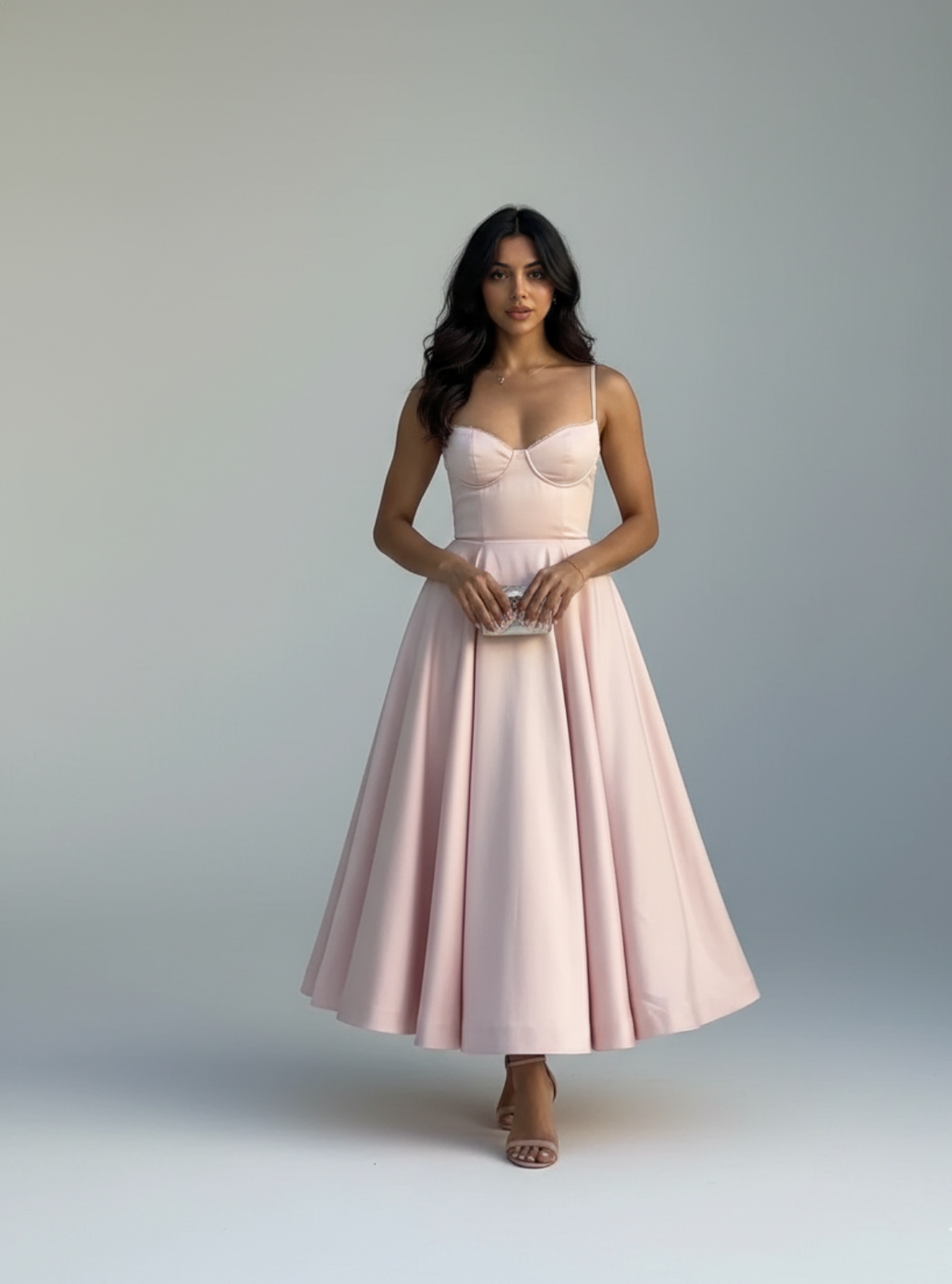 Woman wearing a light pink dress against a plain background