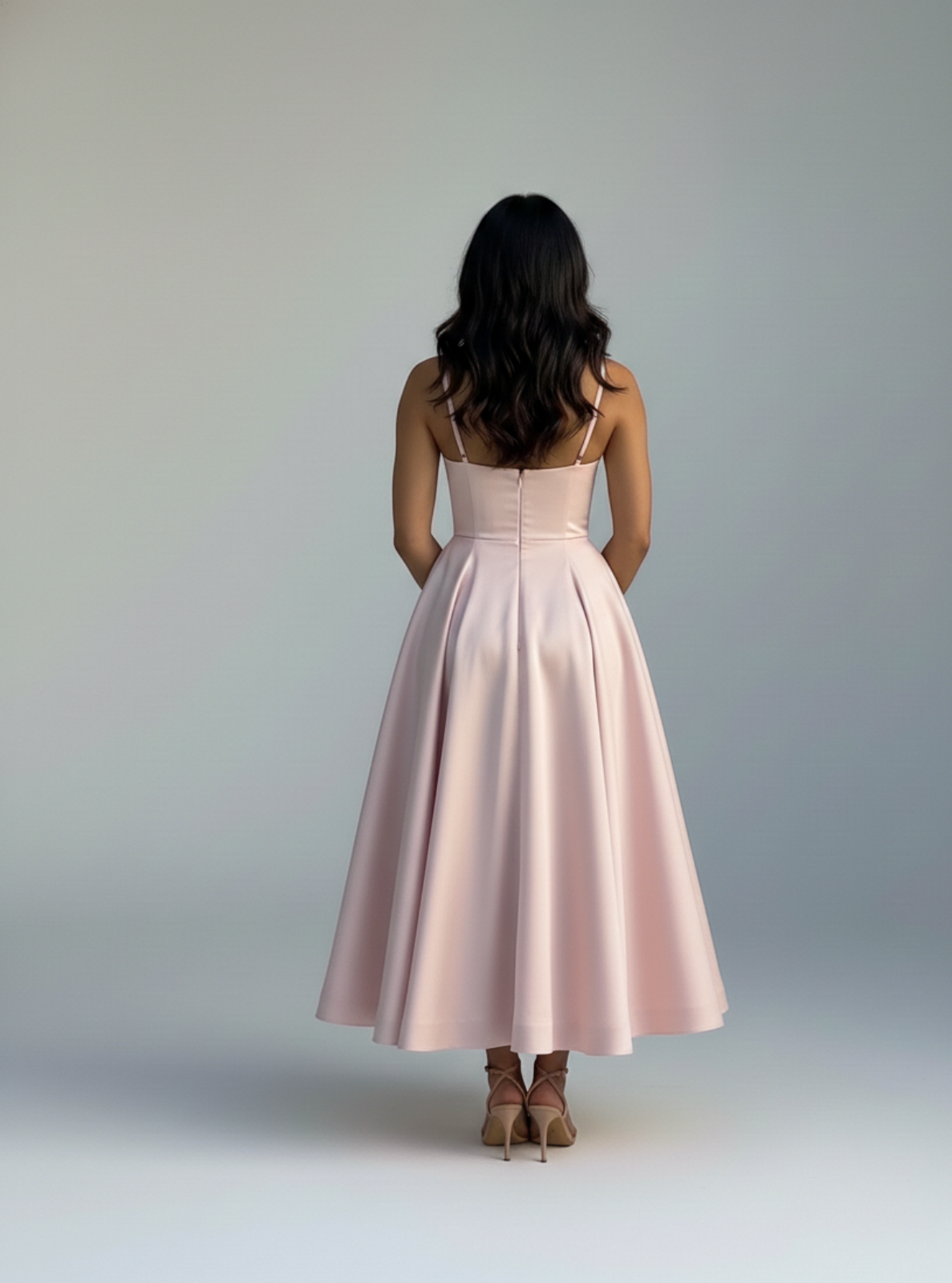 Woman wearing a pink dress against a plain background