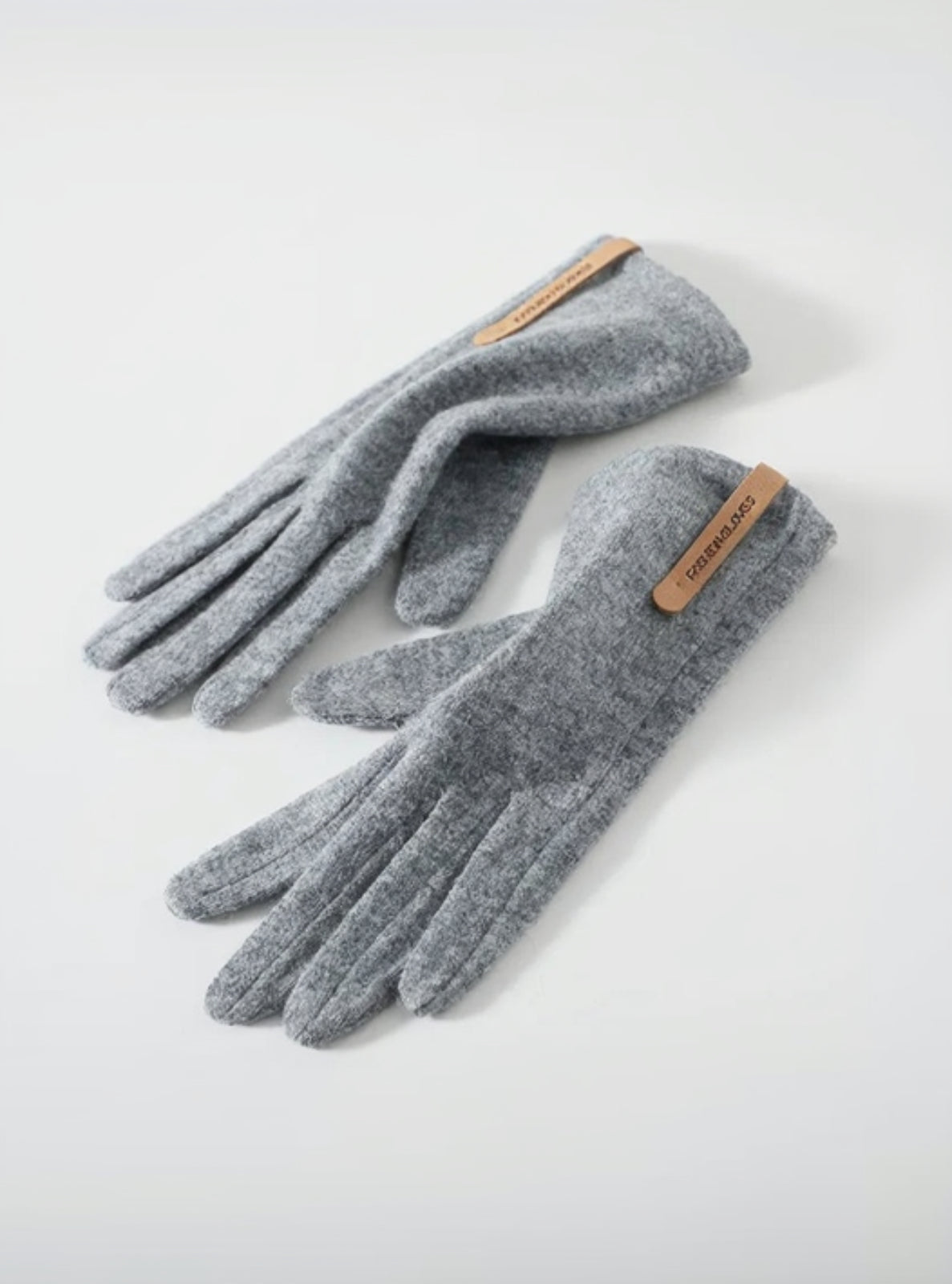 Pair of gray gloves with a brand label on a white background