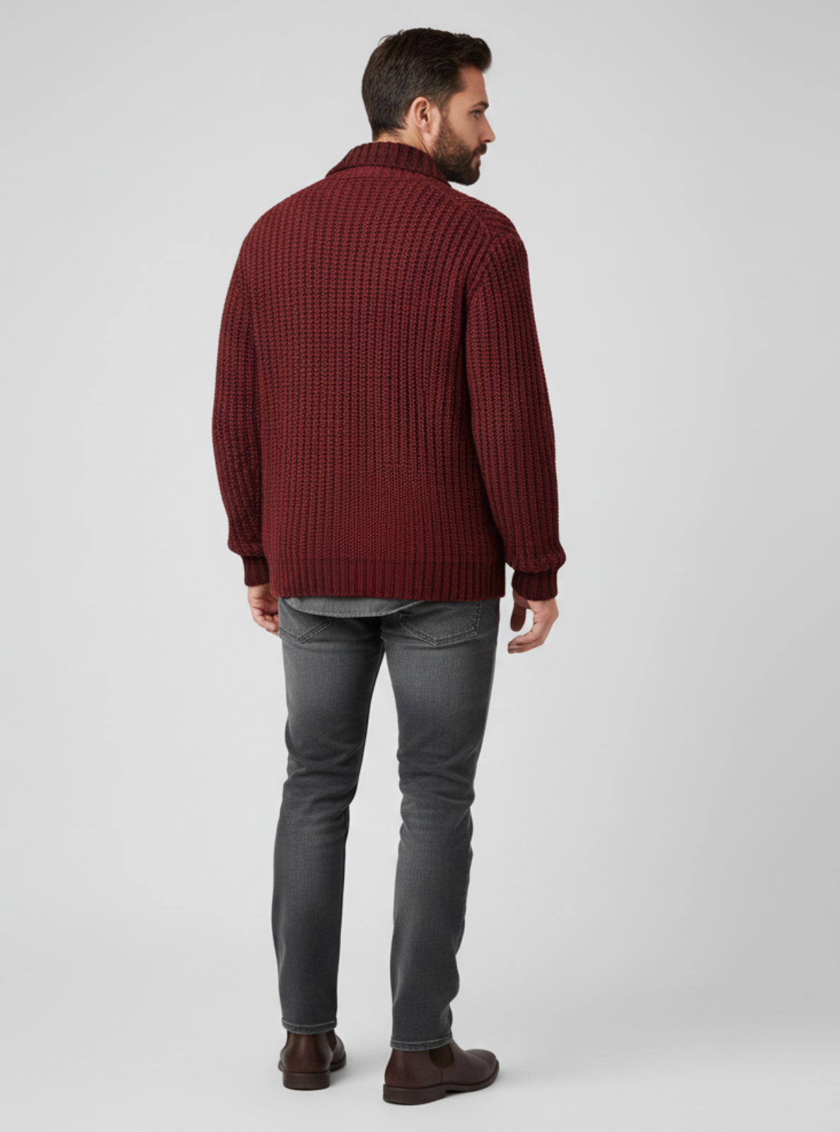 Man wearing a burgundy sweater and gray pants on a white background