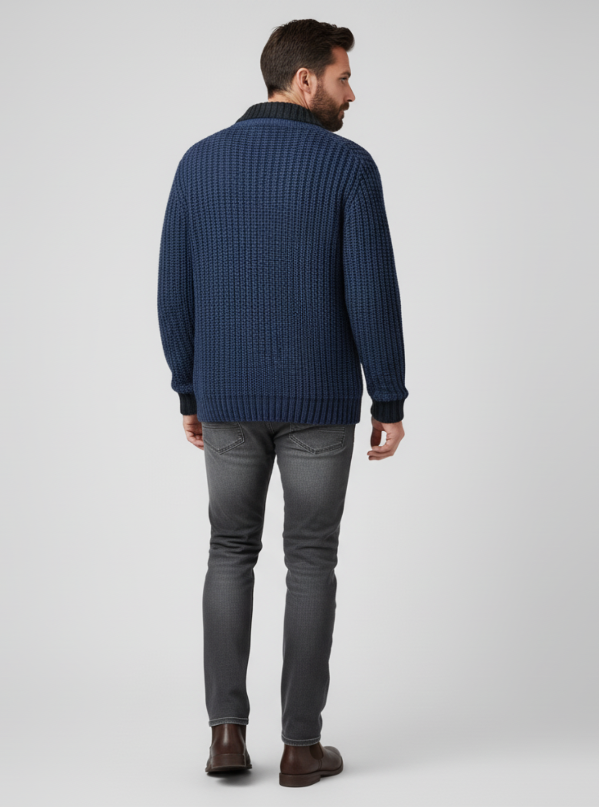 Man wearing a blue knitted sweater and gray pants on a white background