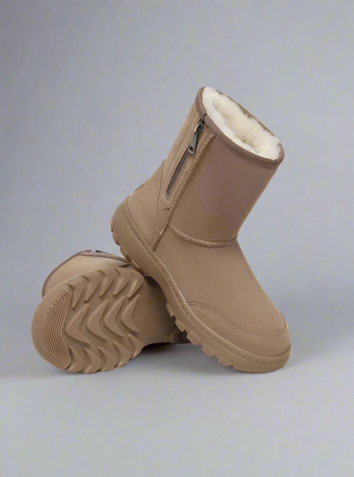 Pair of brown winter boots with white fur lining on a light gray background
