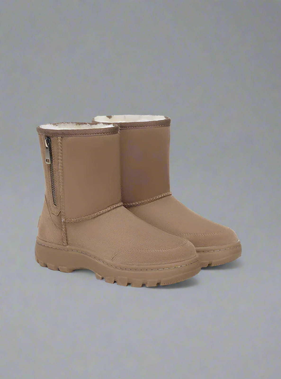 Pair of tan boots on a gray background