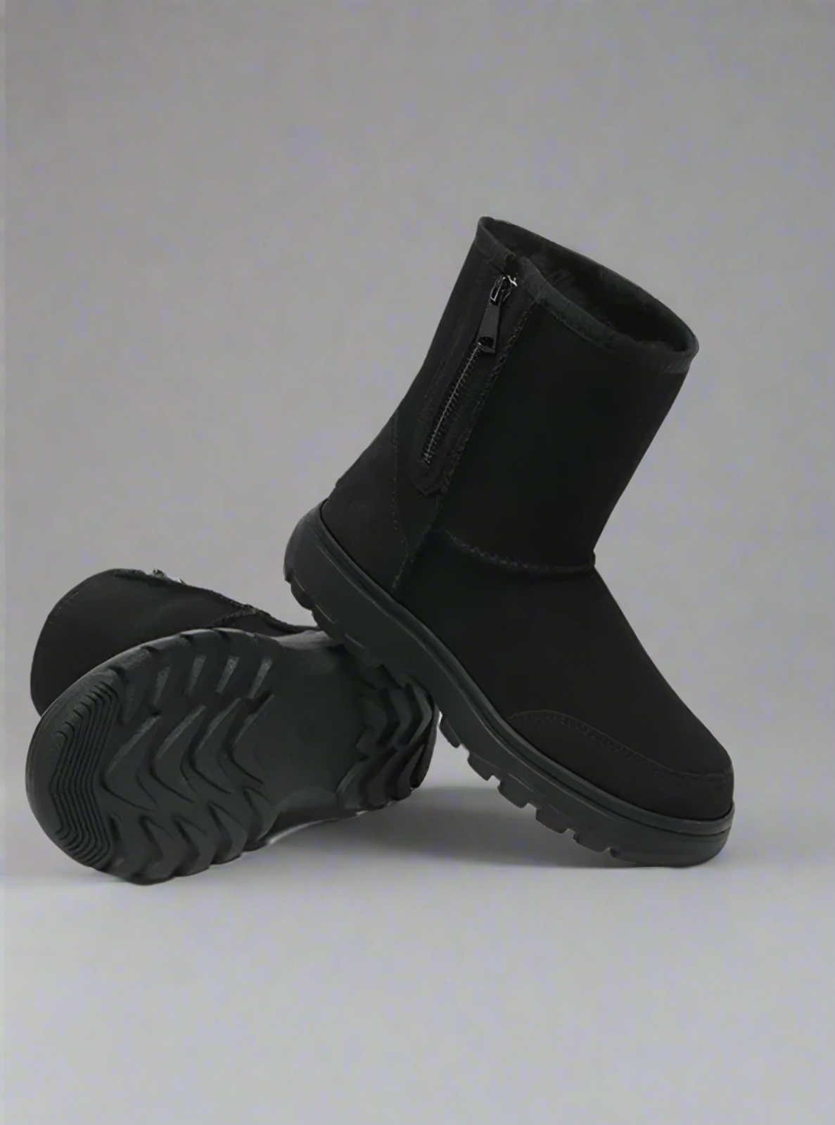 Pair of black winter boots on a light gray background