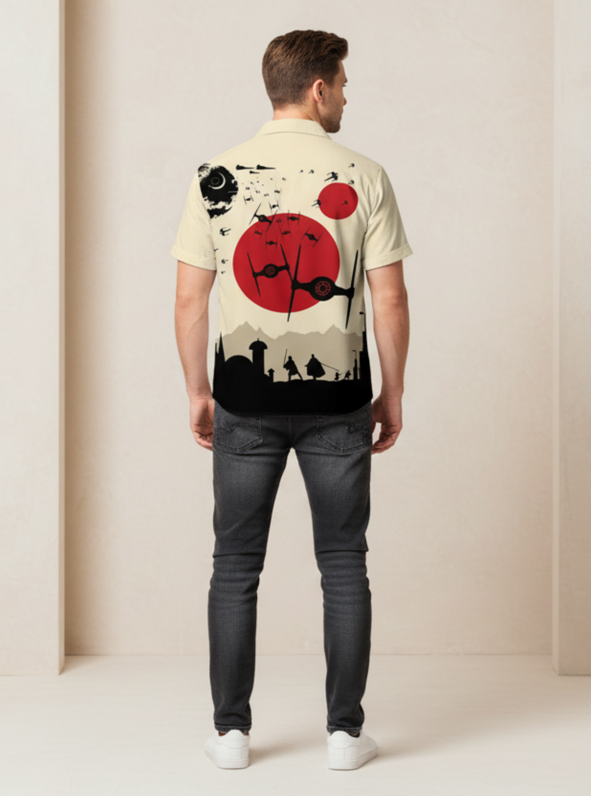 Man wearing a shirt with a graphic design on the back, standing against a plain background