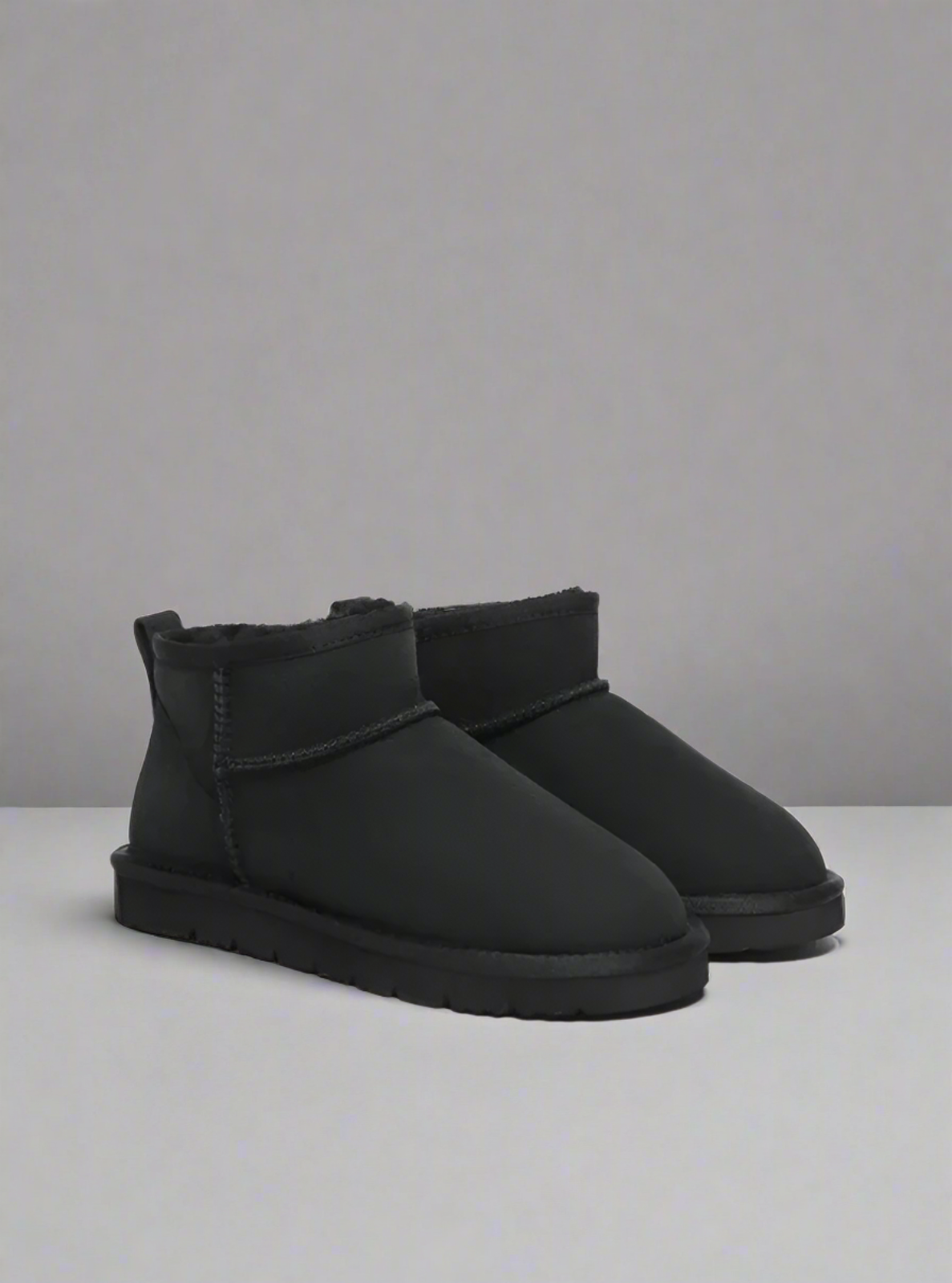 Black boots displayed on a plain background
