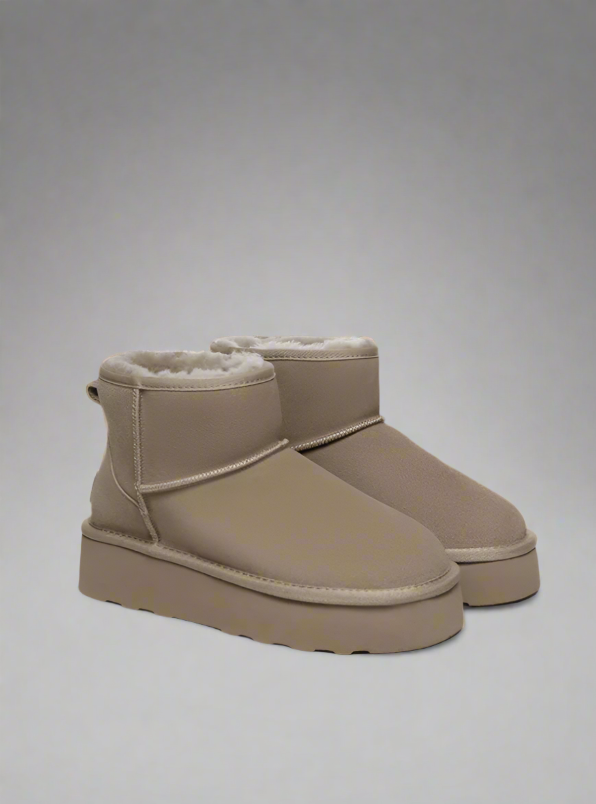 Pair of beige winter boots on a white background