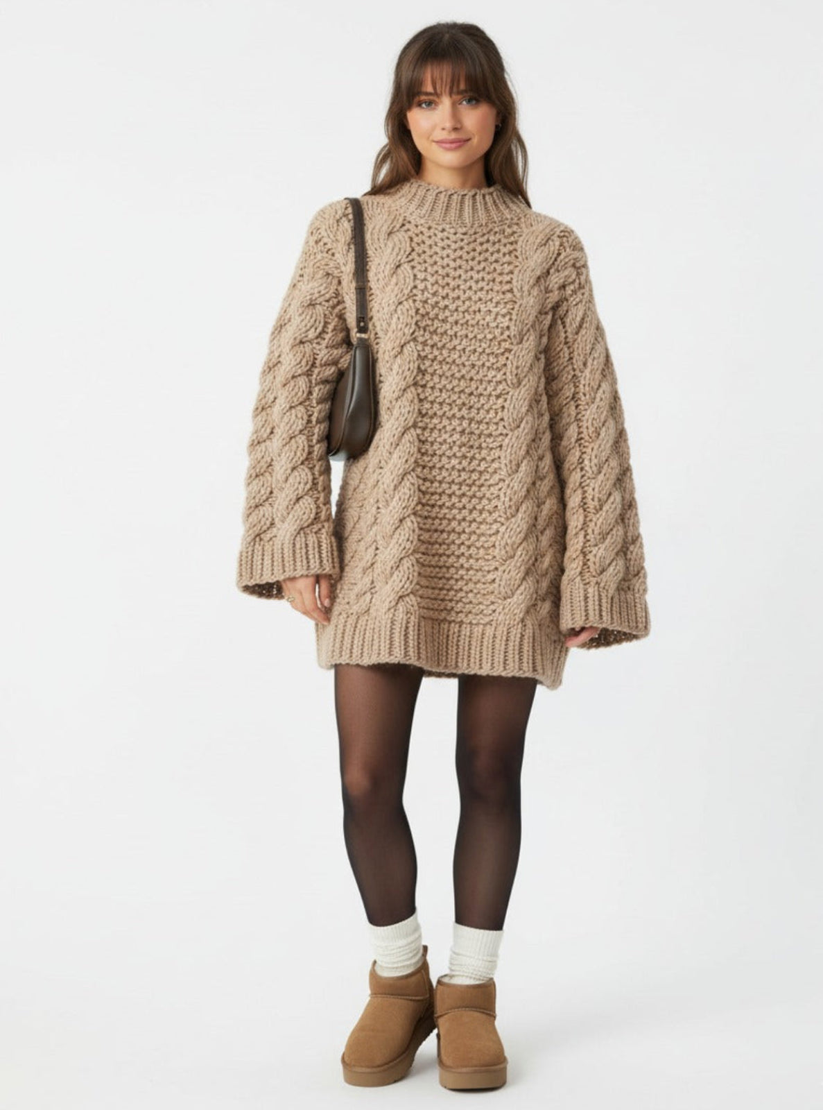 Woman wearing a beige knitted sweater dress with brown boots on a white background