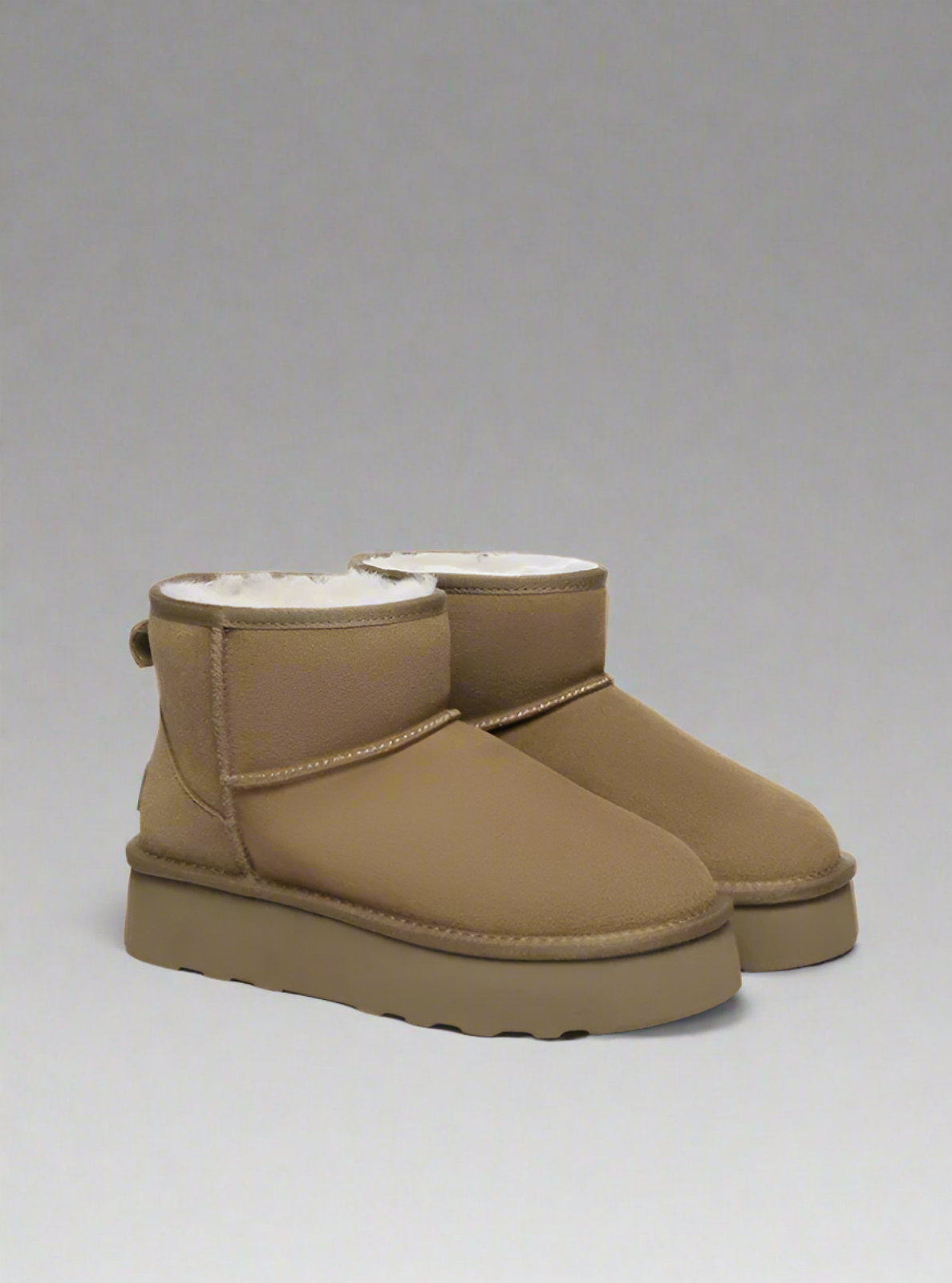 Pair of tan UGG boots on a white background