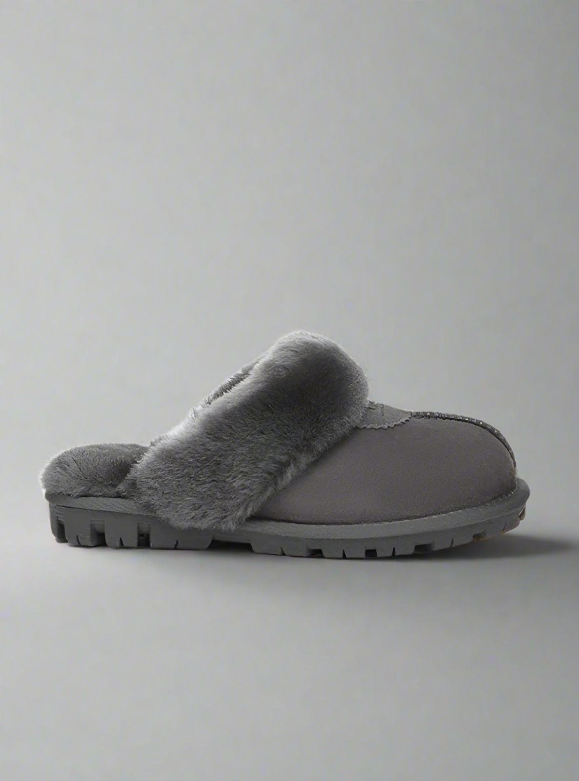 Gray slipper with fuzzy trim on a light gray background
