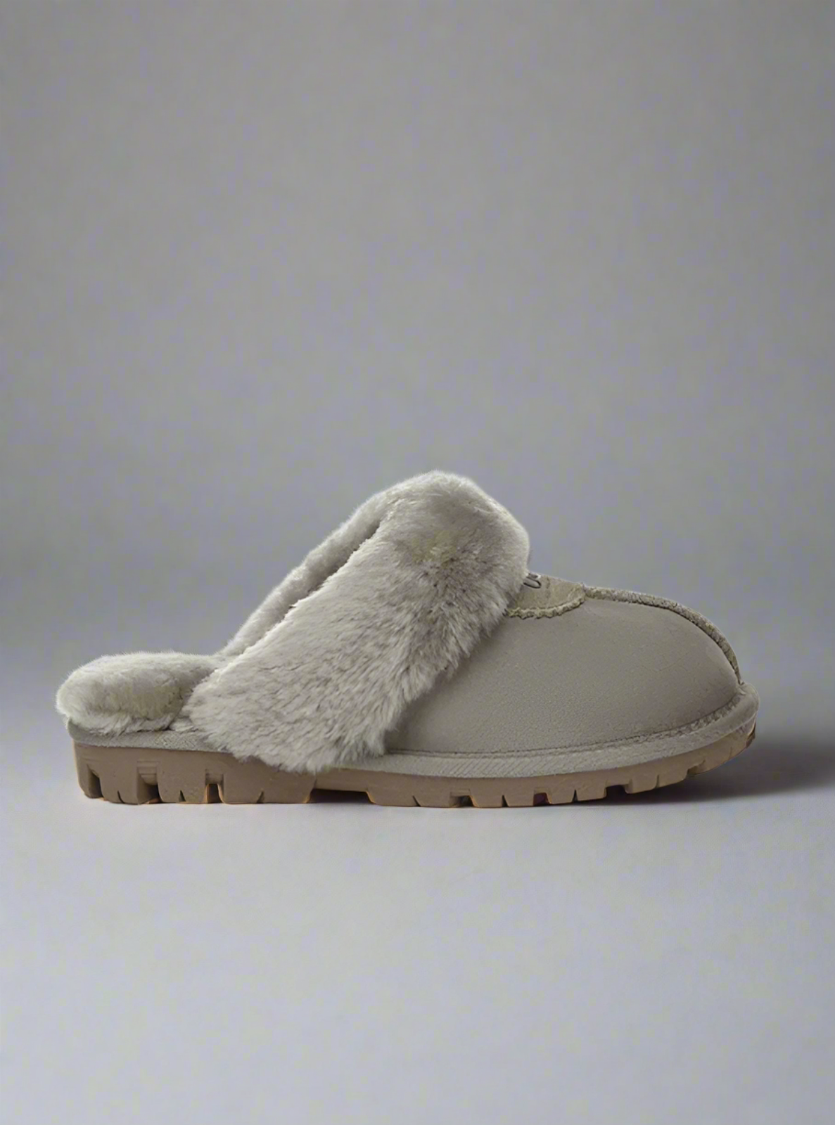 Beige slipper with fur lining on a light gray background