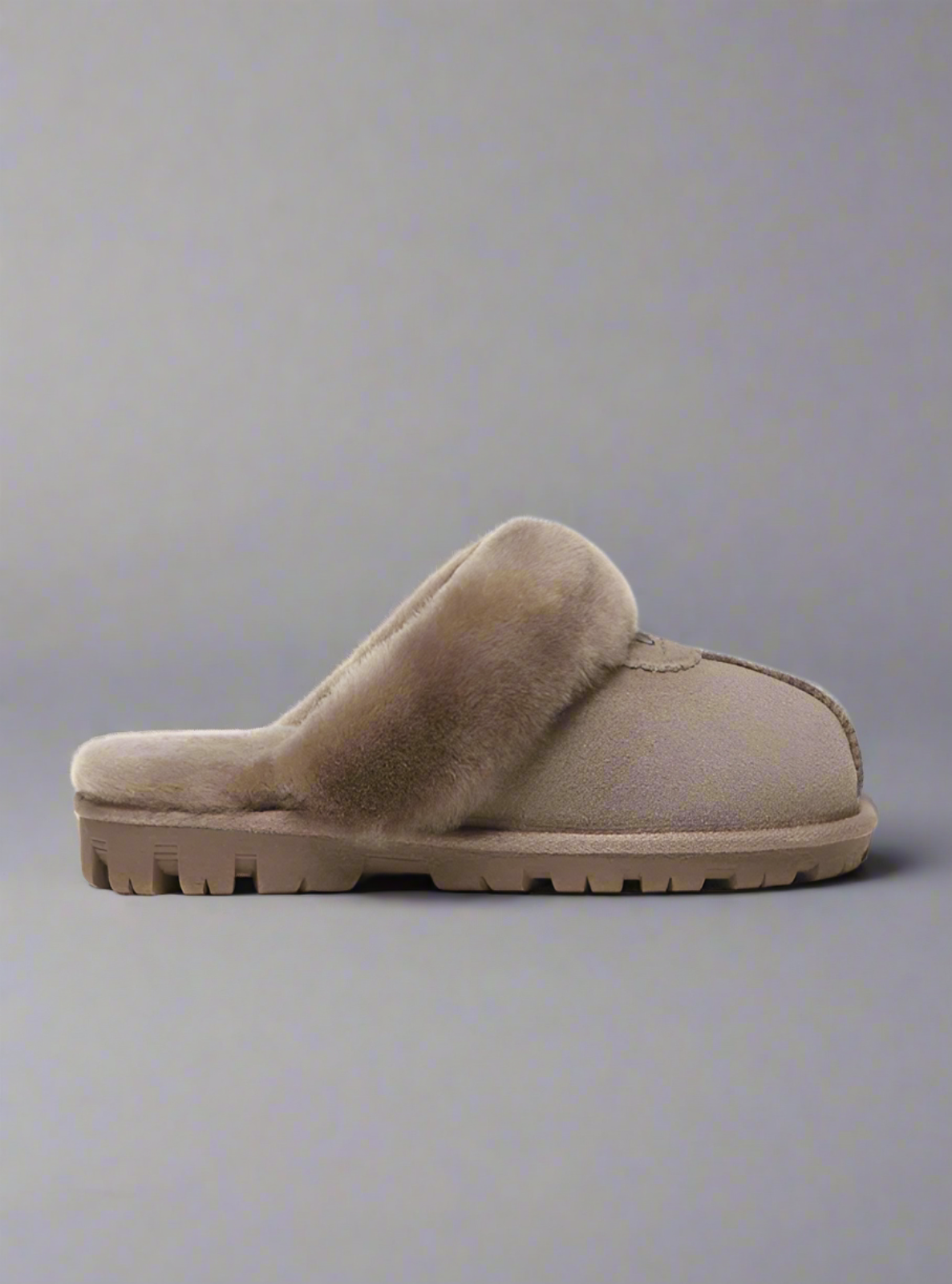 Brown slipper with fuzzy interior on a white background