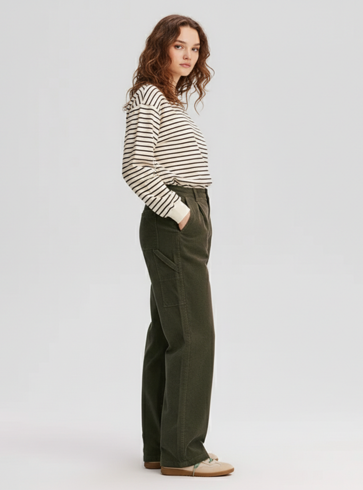 Woman wearing a striped shirt and green pants on a white background