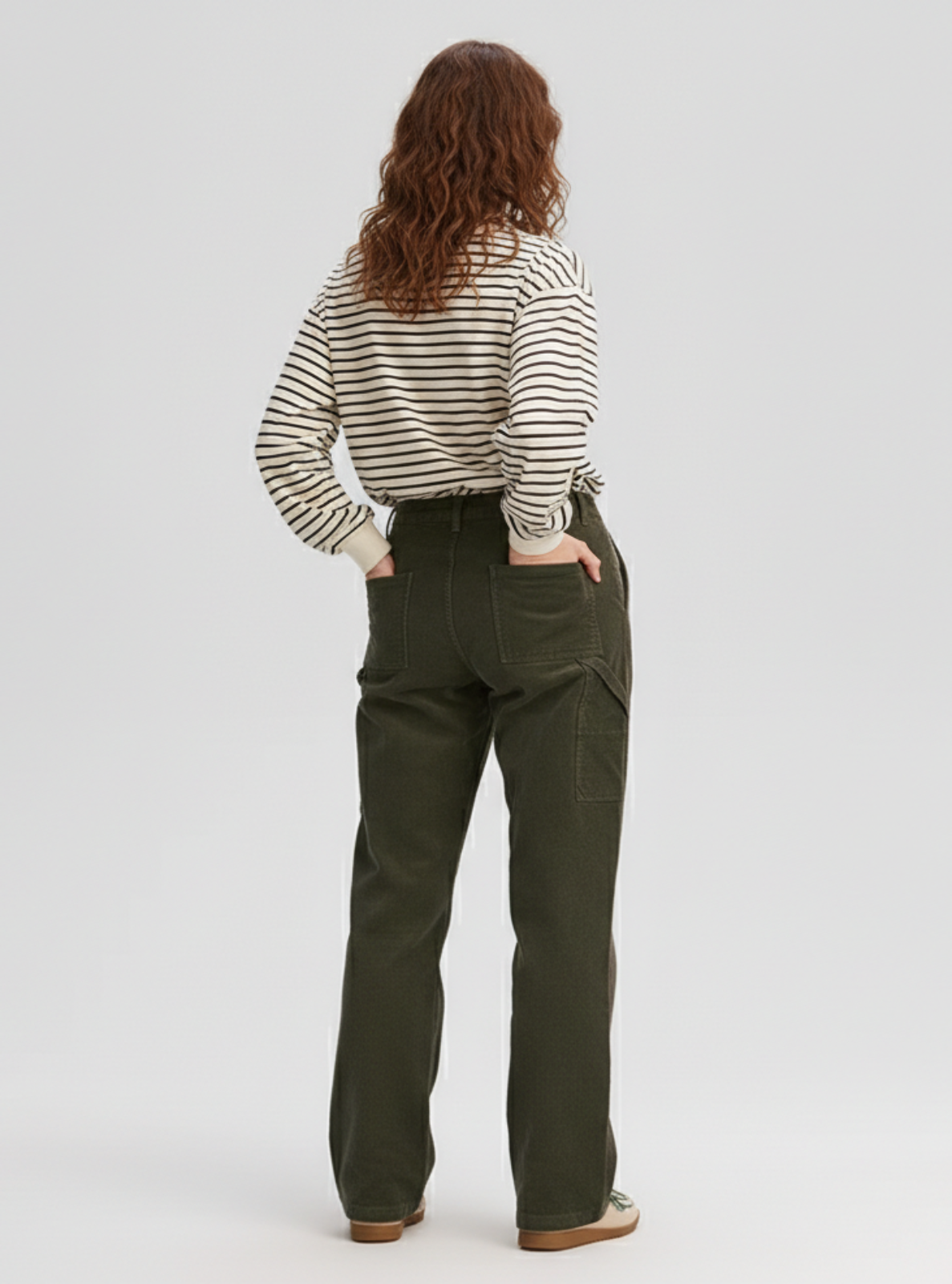 Person wearing a striped shirt and green pants on a white background
