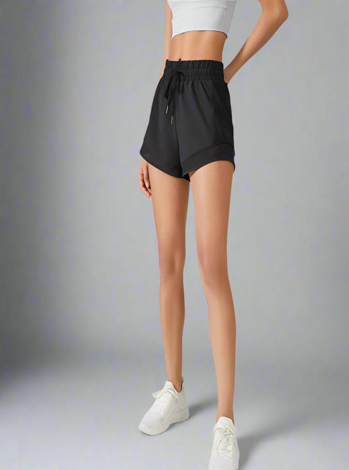 Person wearing black shorts with a white background