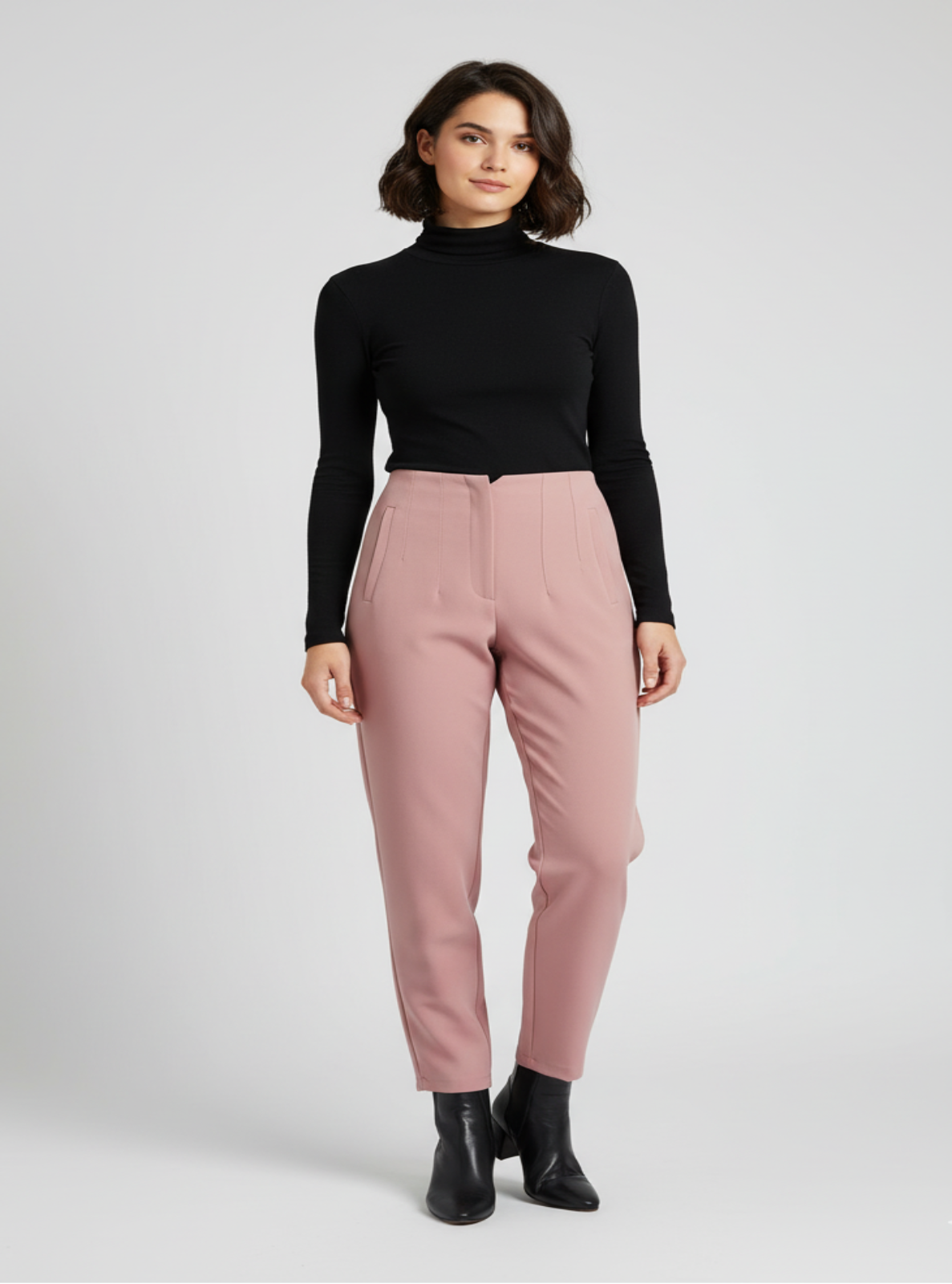 Woman wearing a black turtleneck and pink pants on a white background