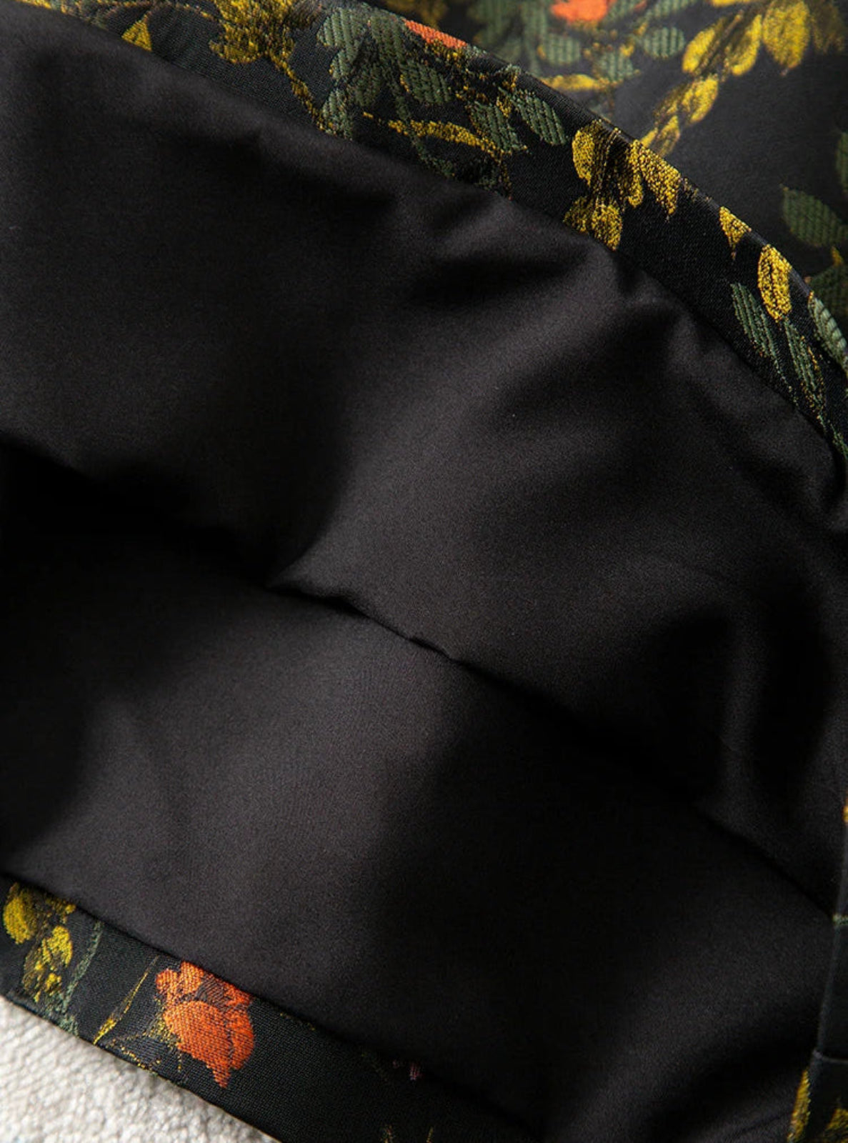 Close-up of black fabric with a floral pattern in the background