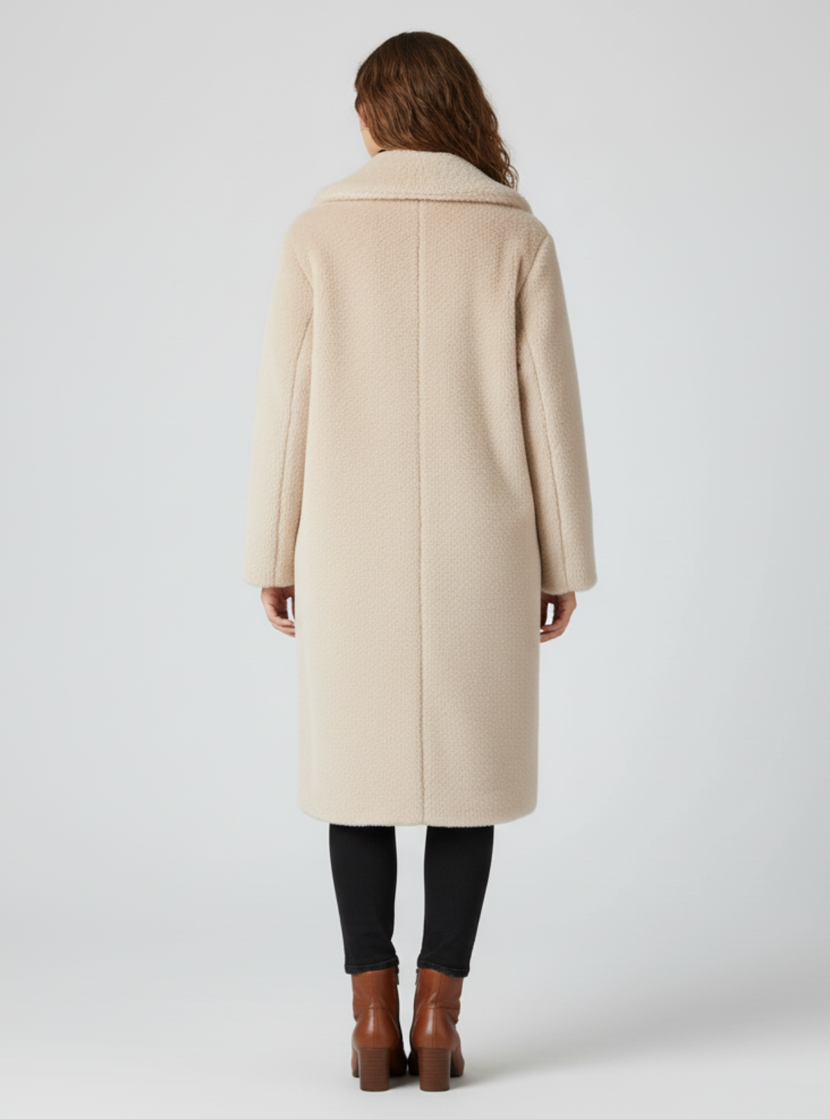 Woman wearing a beige coat on a white background