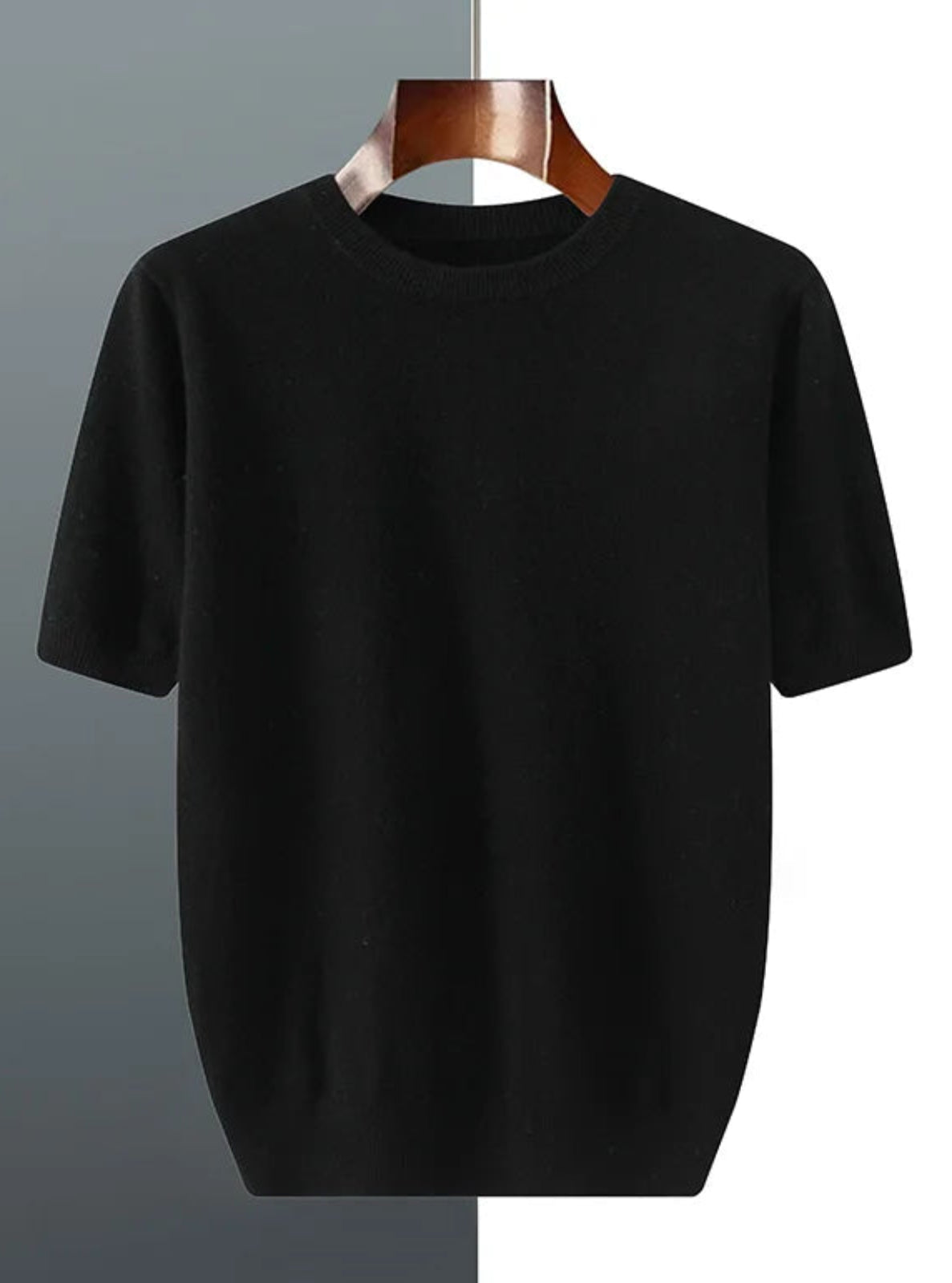 Black t-shirt on a hanger against a gradient background