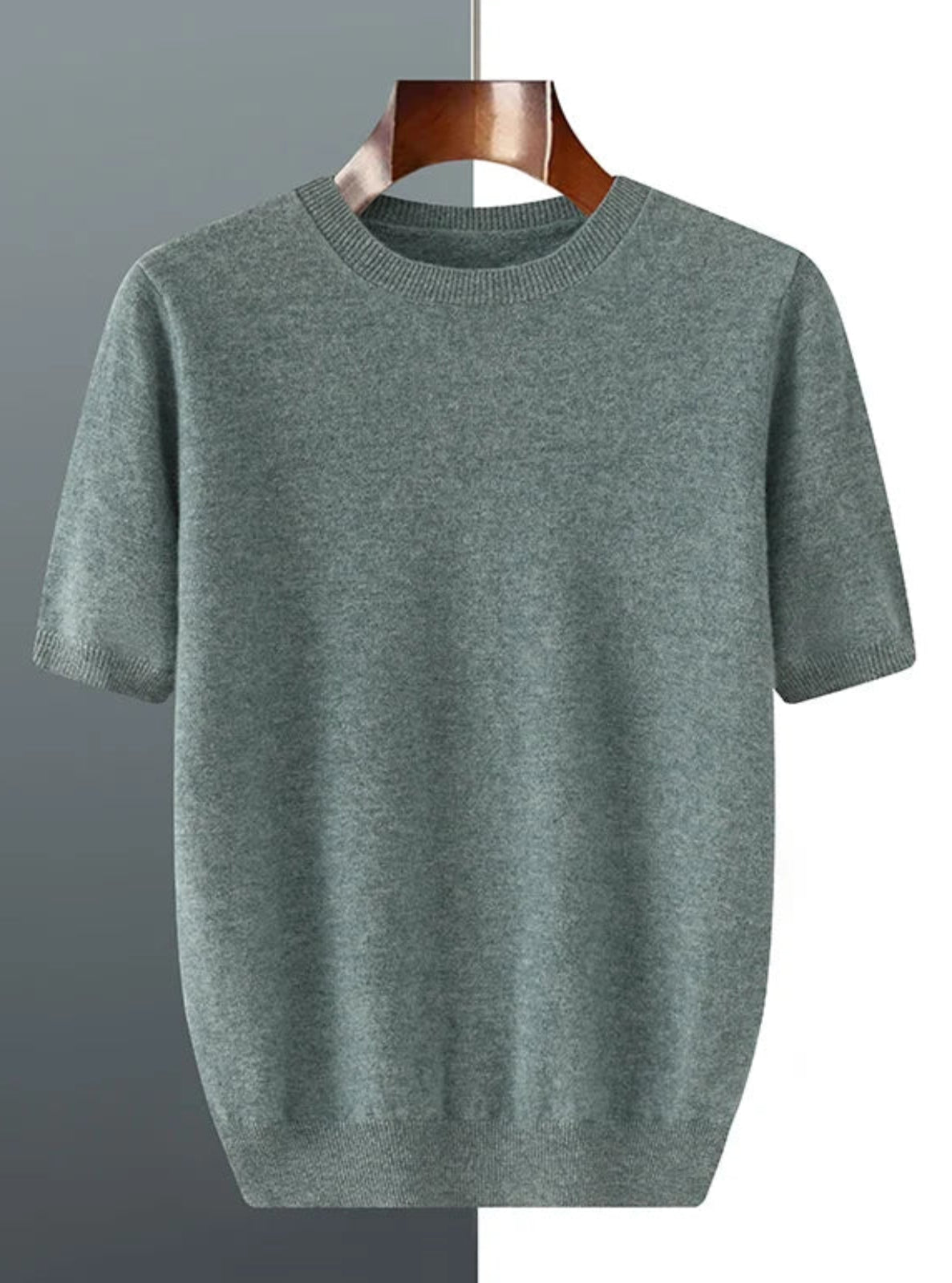 Green t-shirt on a hanger against a gray background