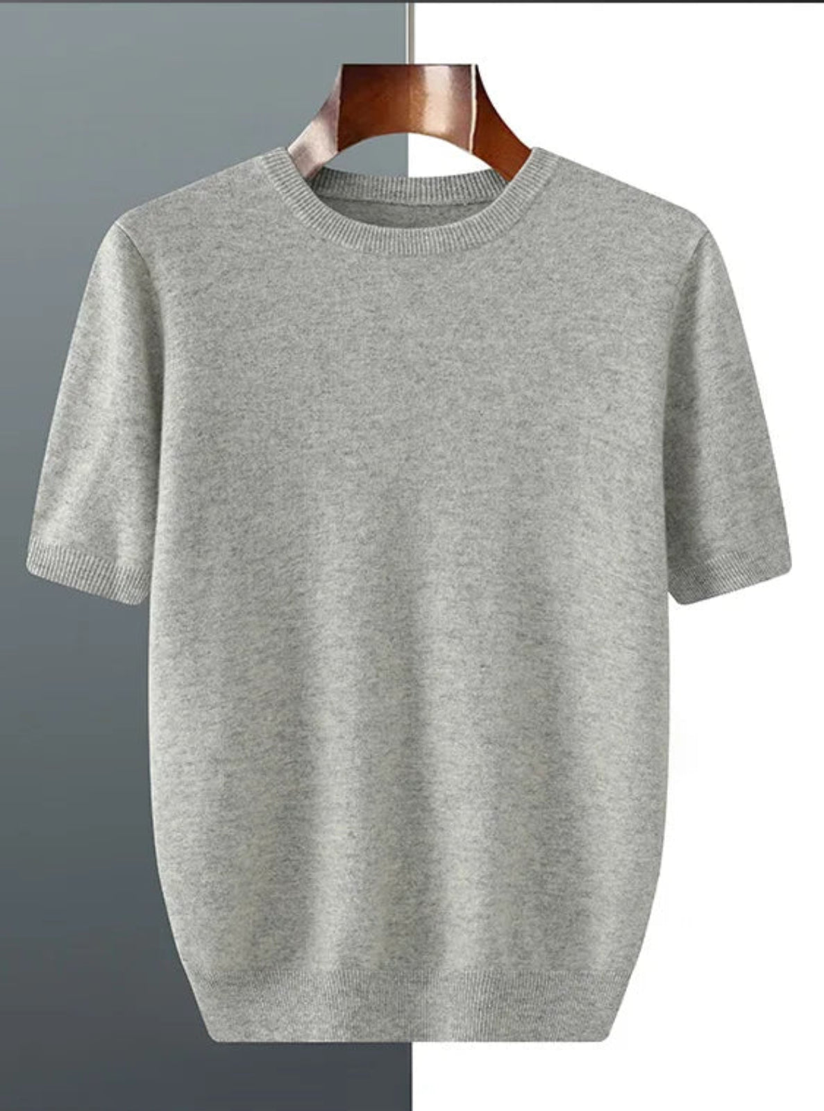 Gray t-shirt on a wooden hanger against a gray background