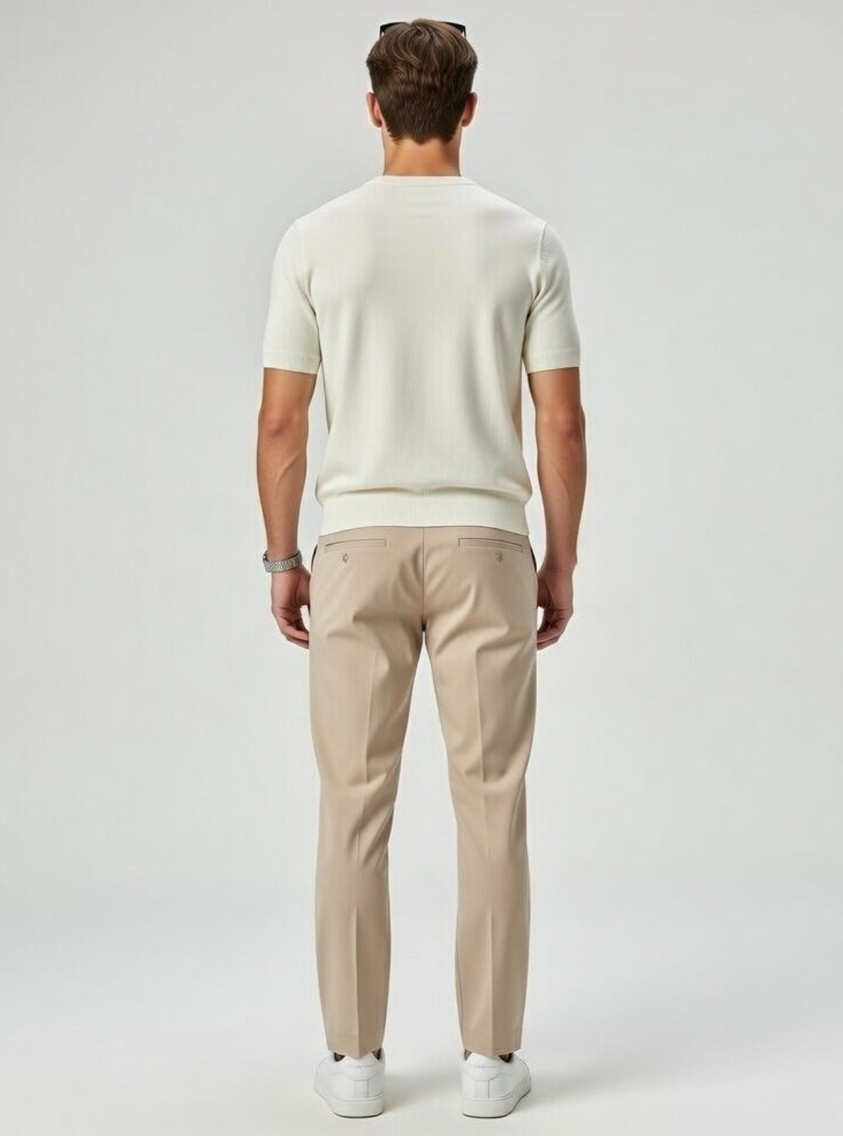 Man wearing a white t-shirt and beige pants on a plain background