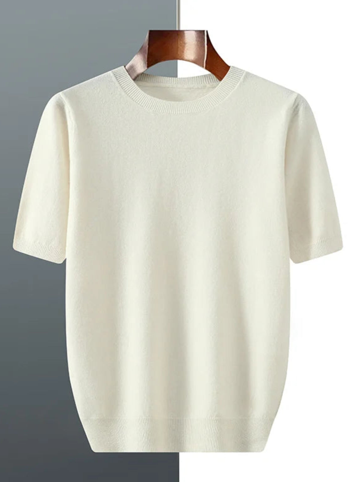 Beige t-shirt on a wooden hanger against a gray and white background