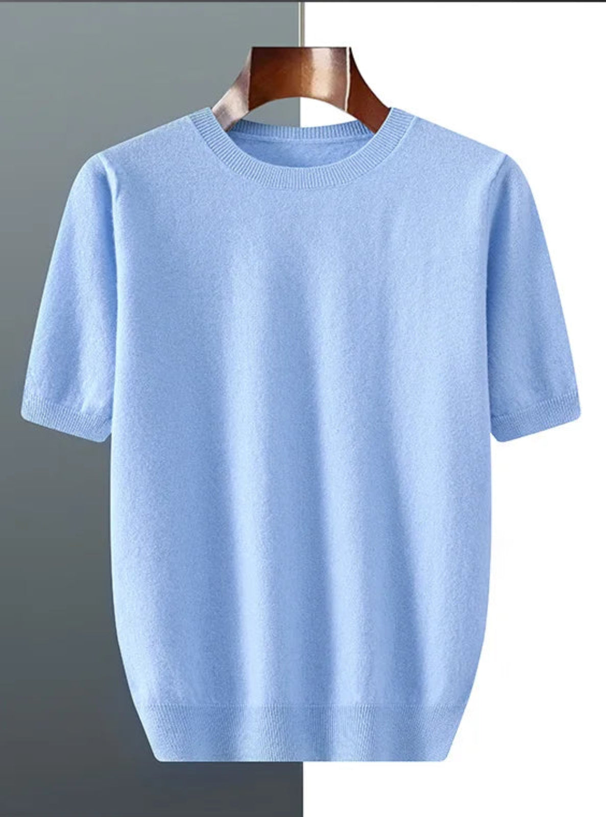 Light blue t-shirt on a wooden hanger against a gray background