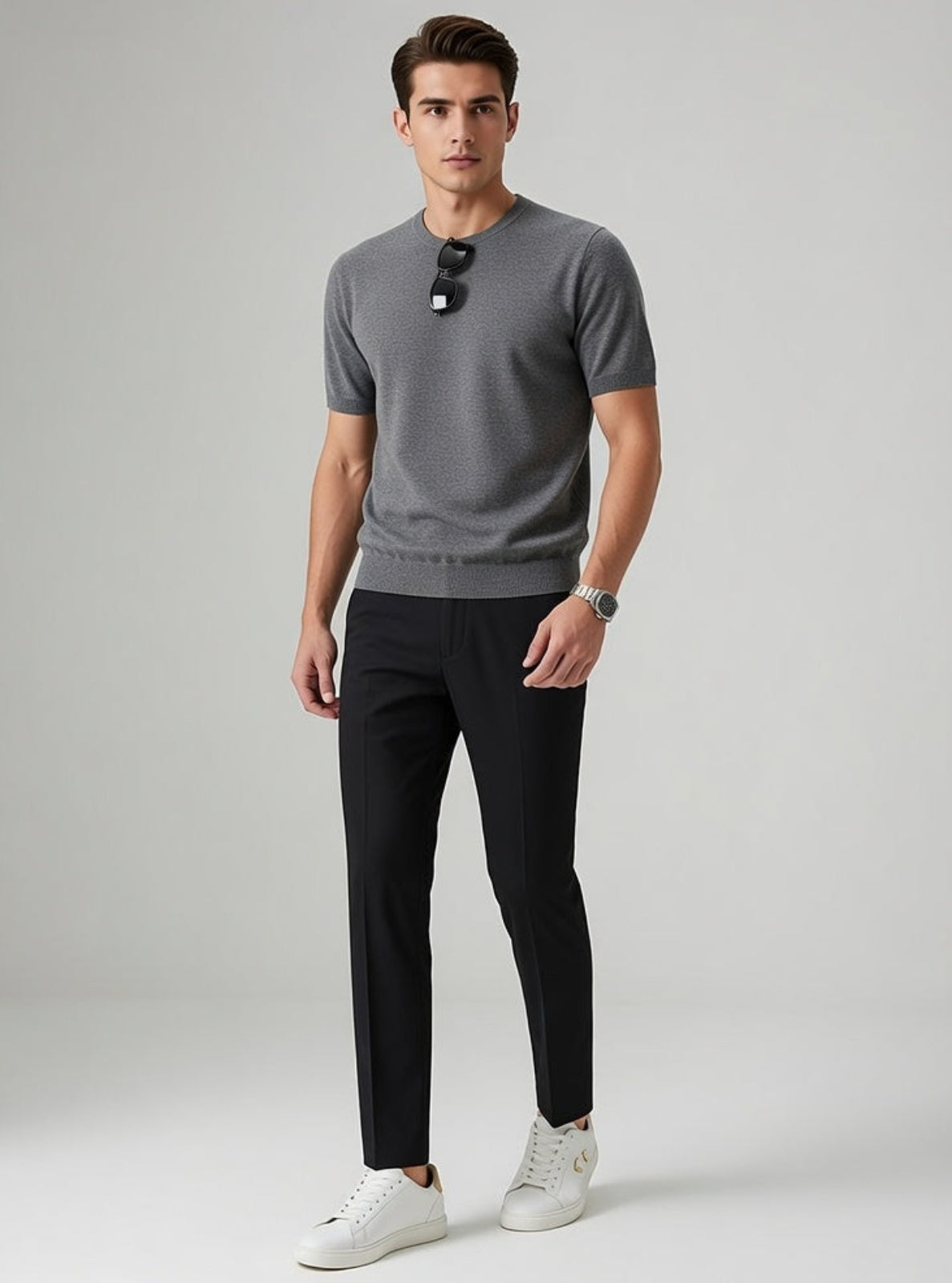 Man wearing a gray sweater and black pants on a light gray background