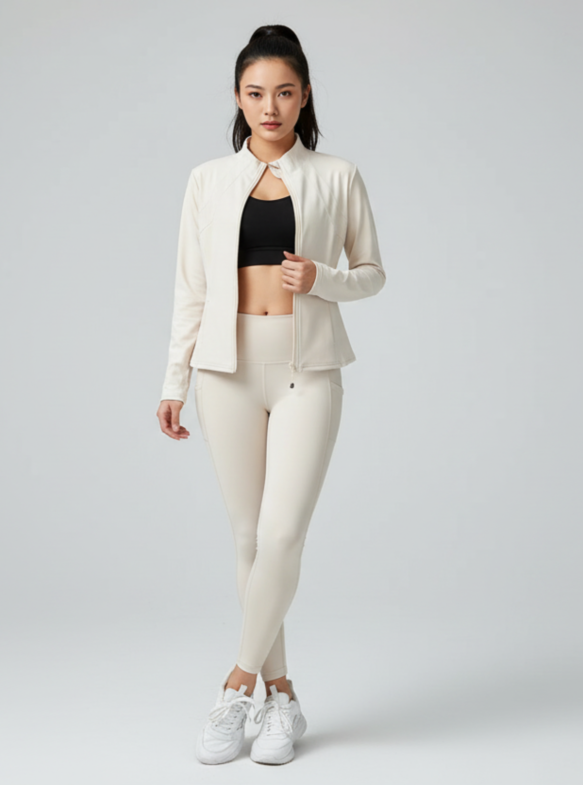 Woman wearing a white outfit with a black top on a gray background