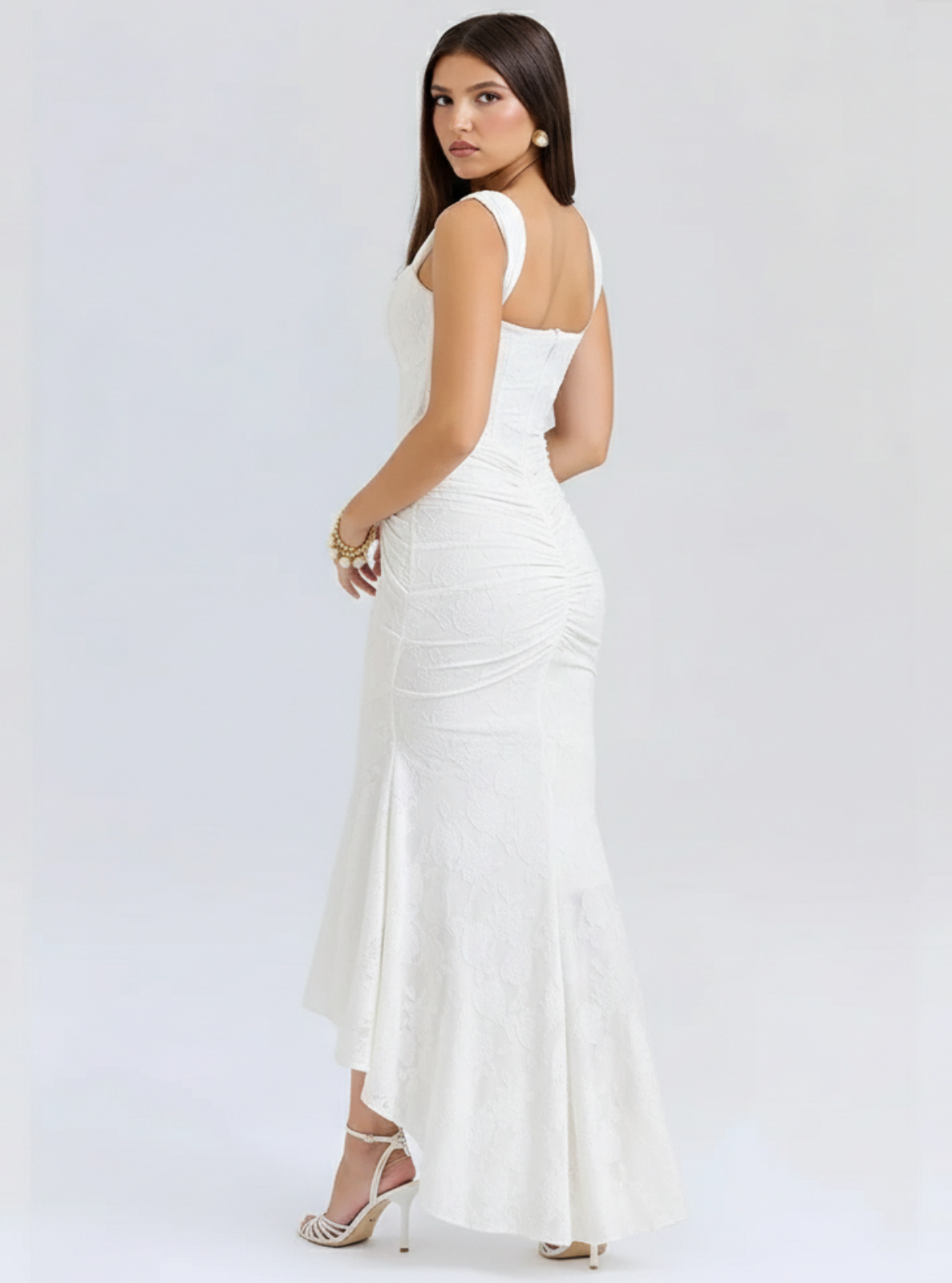 Woman wearing a white evening gown on a plain background