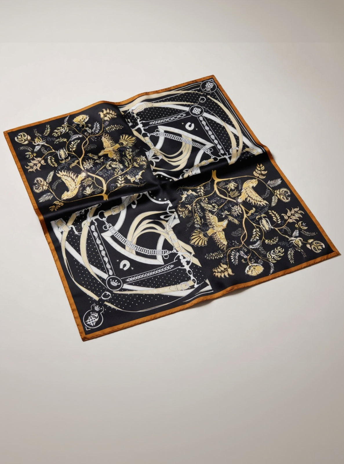Decorative tablecloth with intricate gold and white patterns on a black background