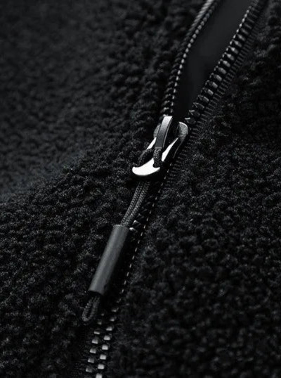 Close-up of a black zipper on a textured fabric background