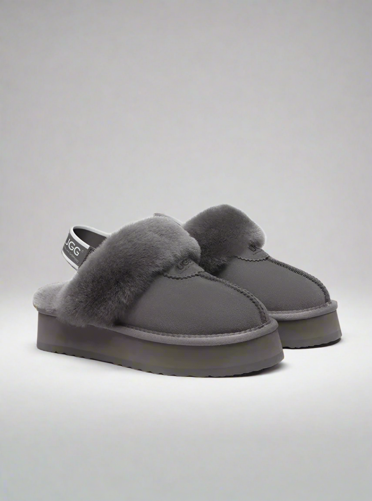 Pair of gray slippers with fuzzy texture on a white background
