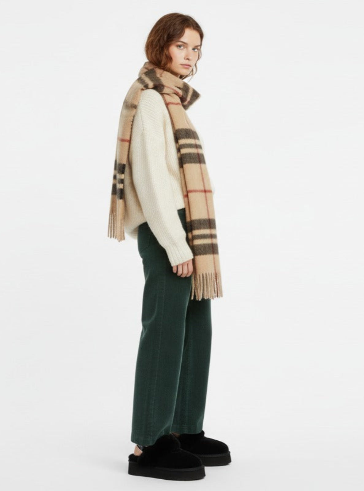Person wearing a plaid scarf and green pants on a white background
