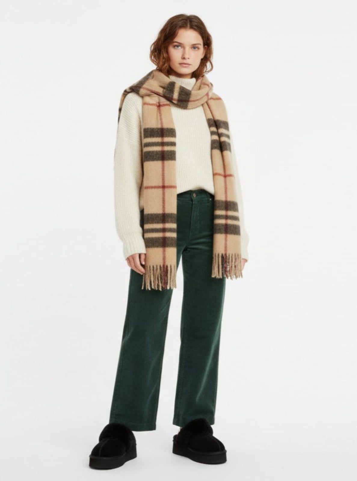 Person wearing a checkered scarf and green pants on a white background