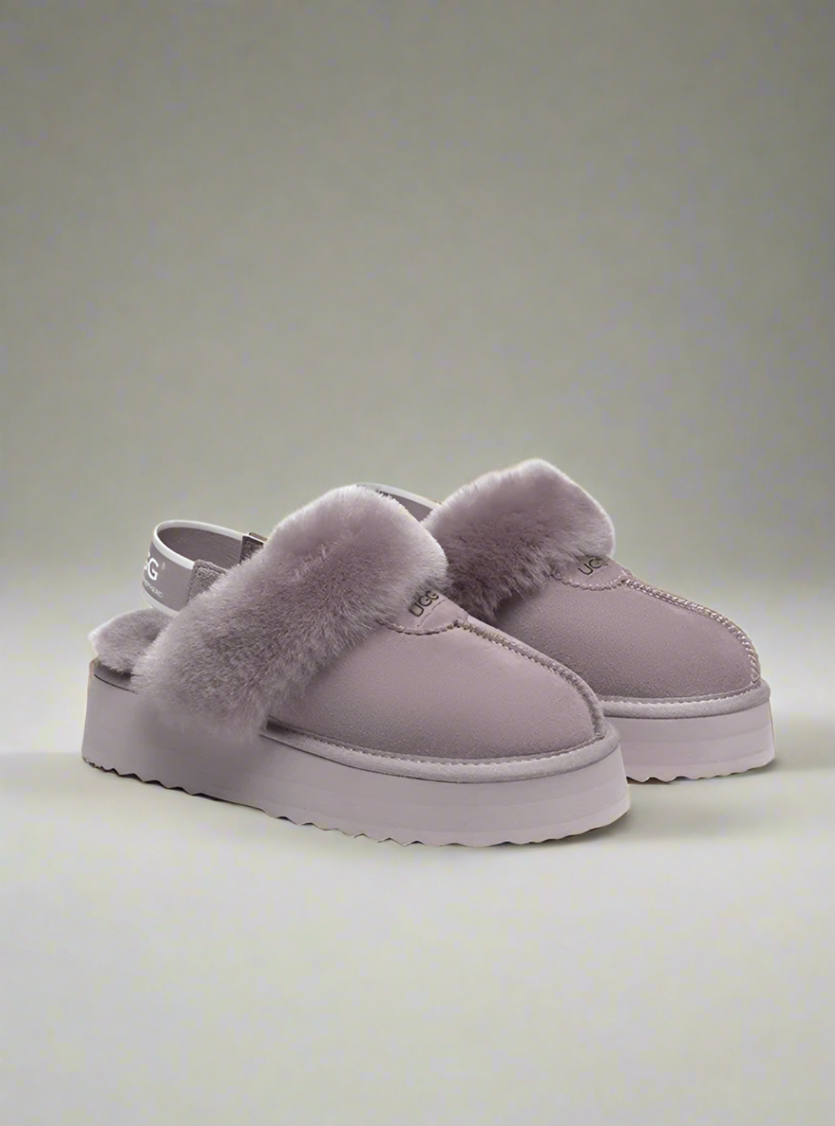 Pair of gray platform shoes with fuzzy texture on a white background