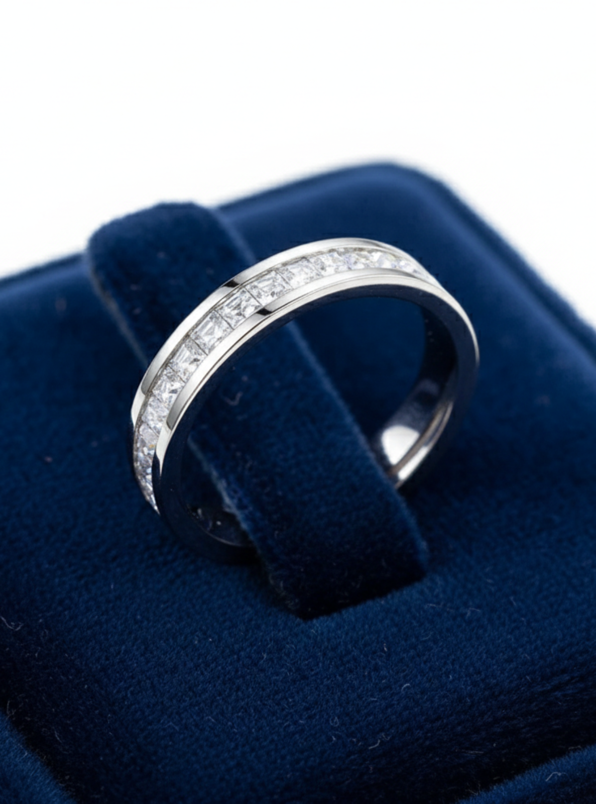 Silver ring with diamonds on a blue velvet cushion
