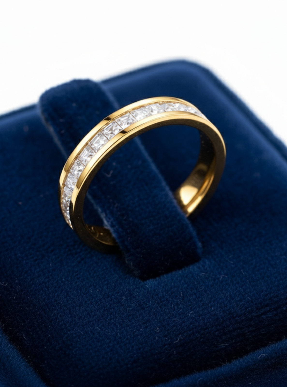Gold ring with diamonds on a blue velvet cushion