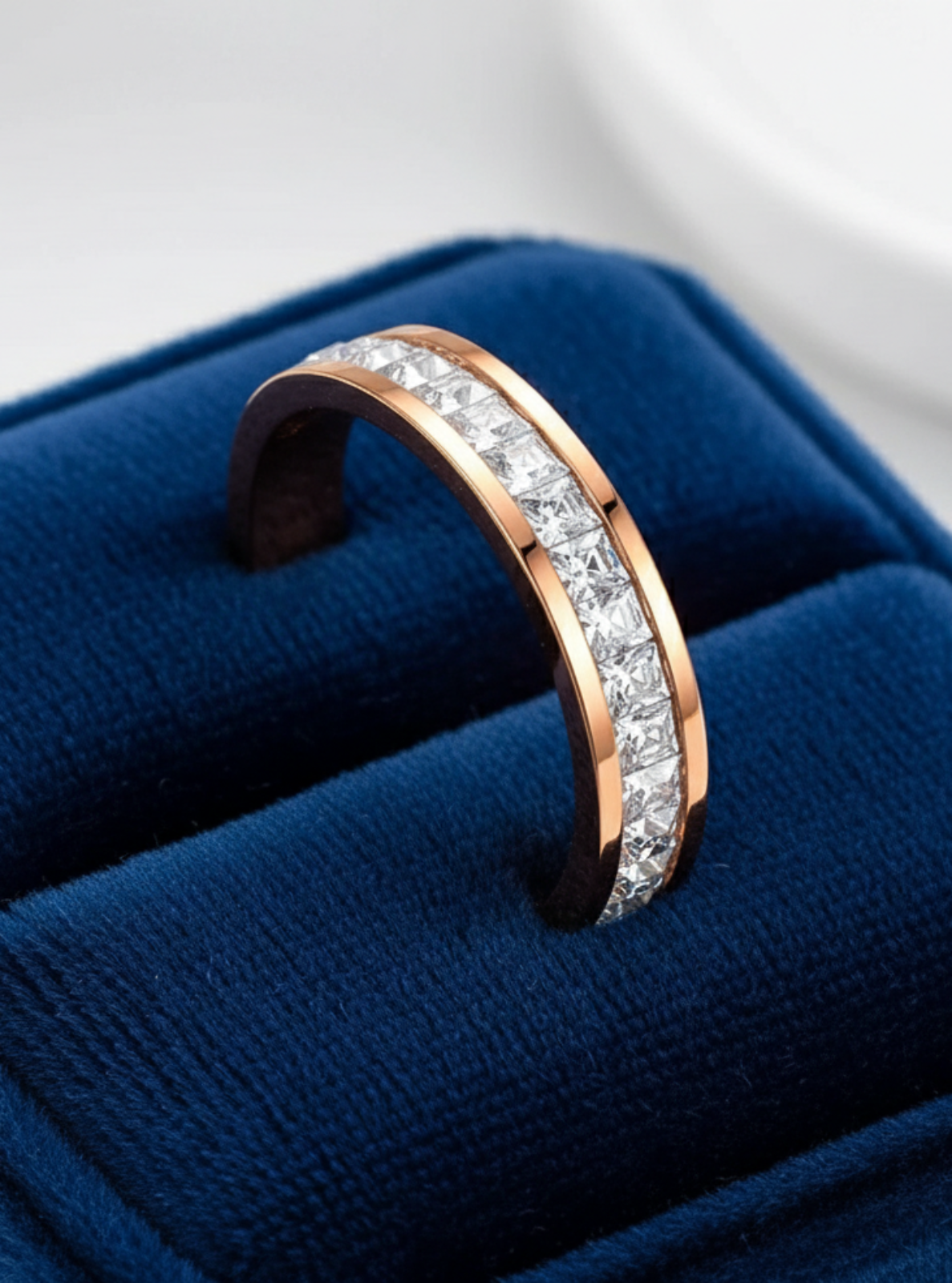Rose gold ring with diamonds on a blue cushion