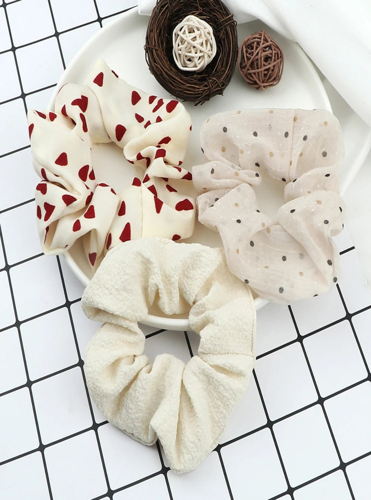 Three scrunchies on a white plate with a grid background